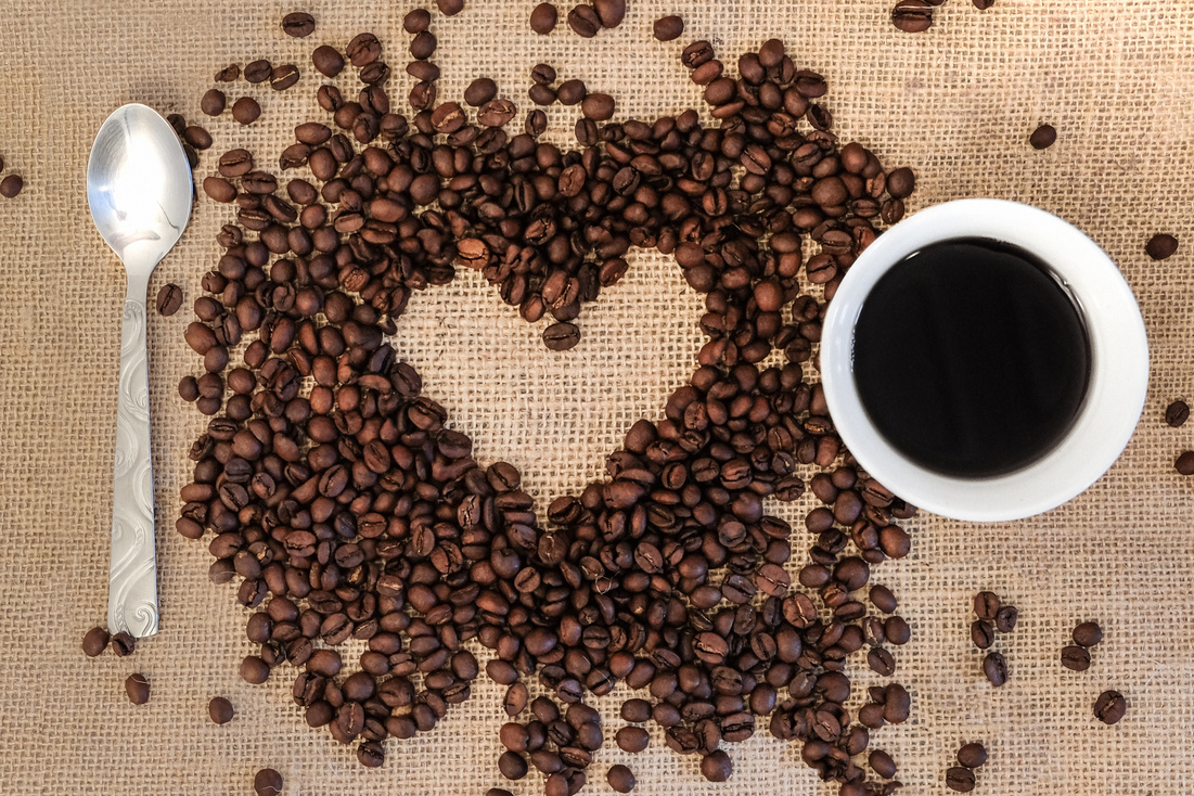 Heart Made of Coffee Beans and Coffee cup on Wooden Background